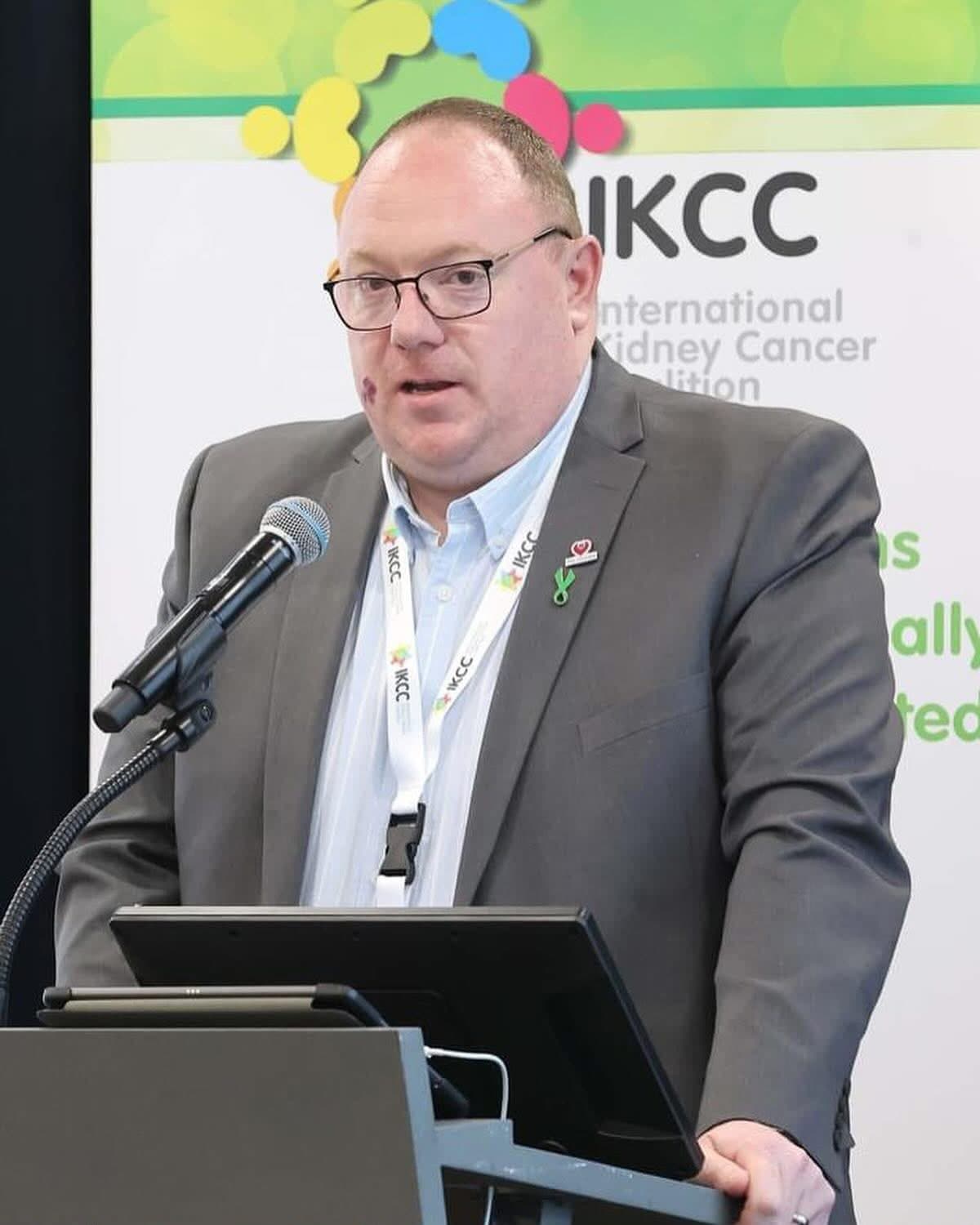 Steve Pointon mid-sentence at a lectern, addressing the International Kidney Cancer Coalition summit